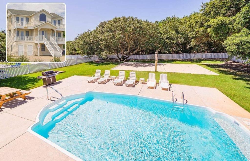 a pool in a yard with chairs and a house at King BEEch - Southern Shores, 300 Yds to Beach, Ocean View, Pool, Hot Hub, Fenced Yard in Southern Shores