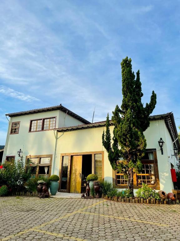 a house with a tree in front of it at Pousada Neuza Barbosa in Tiradentes