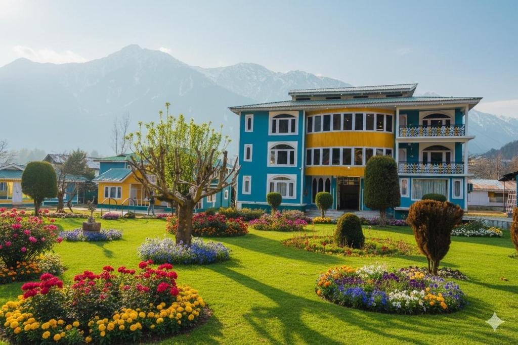 a blue and yellow building with flowers in a park at Pahalgam Resort and Cottages in Pahalgām