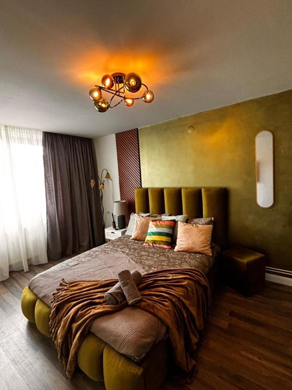 a bedroom with a large bed and a chandelier at GZP Residence Lugoj 21 in Lugoj
