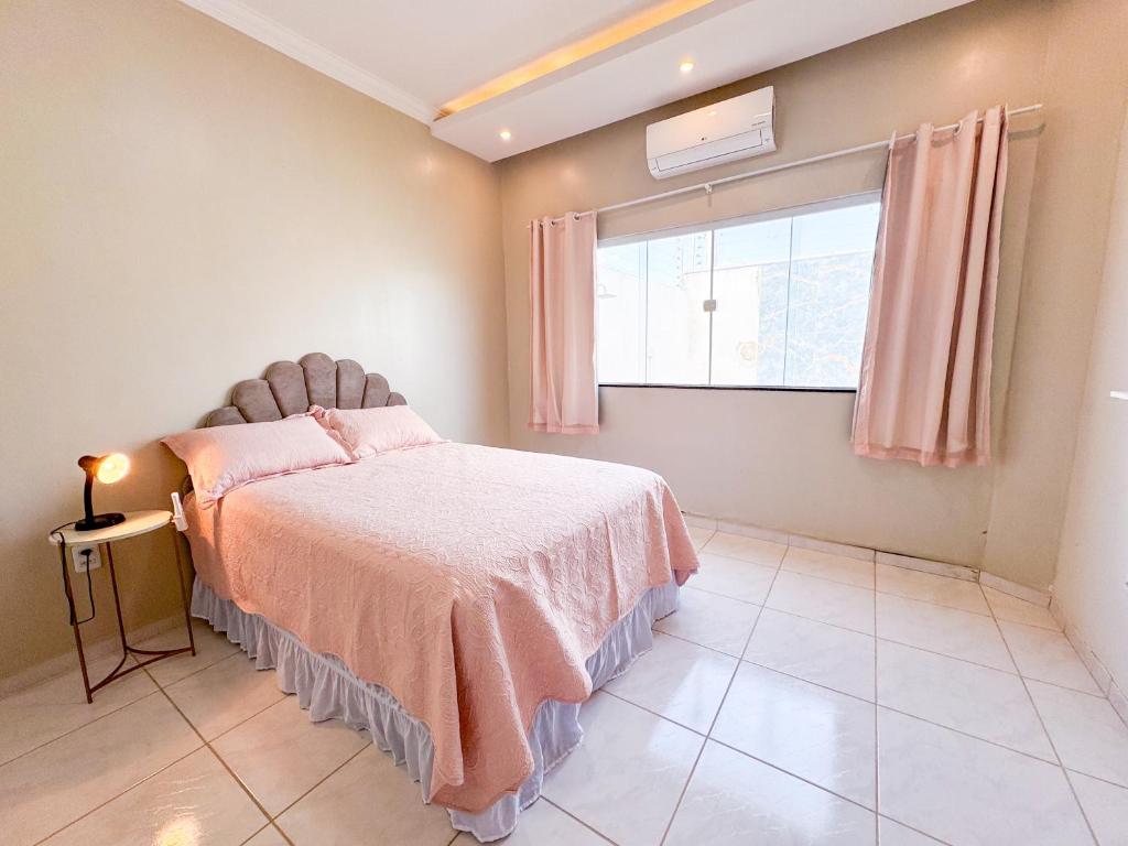 a bedroom with a bed and a window at Casa Vitória-régia in Camocim