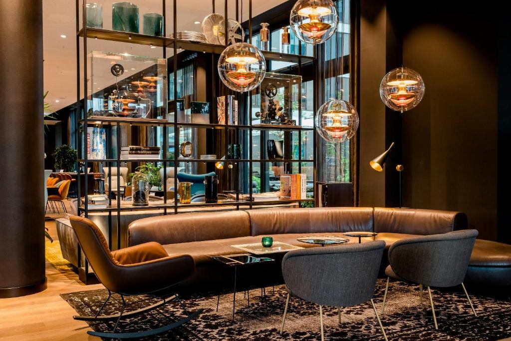 a living room with a couch and a table at Motel One Köln-Messe in Cologne