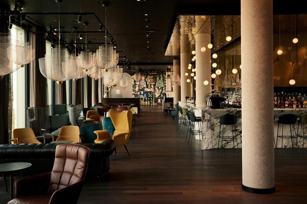 a restaurant with tables and chairs and chandeliers at The Cloud One Prague in Prague