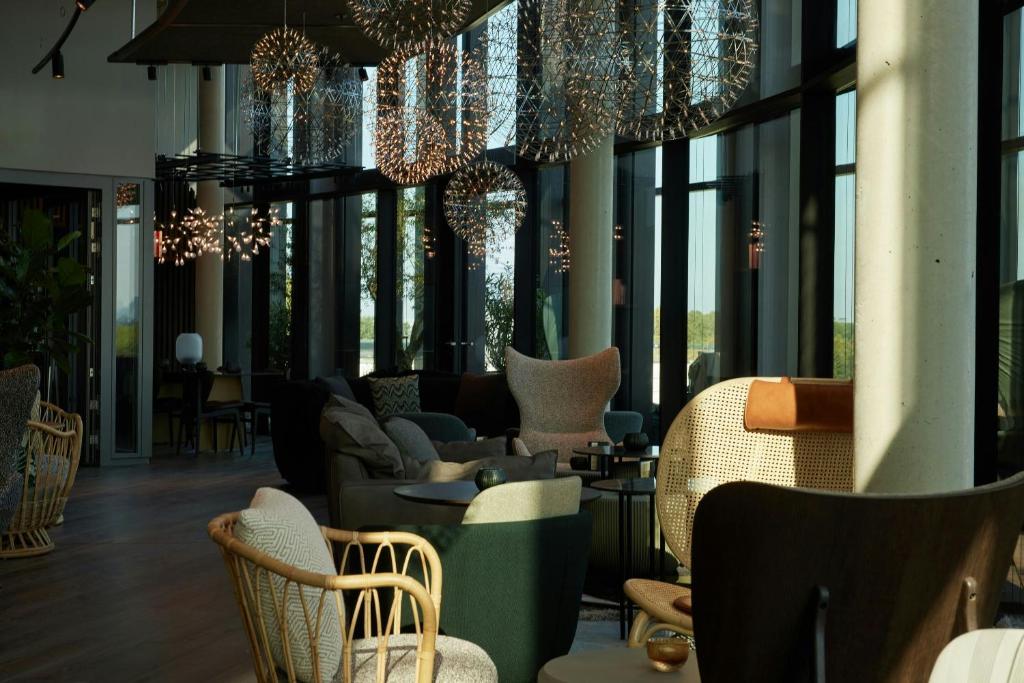 a lobby with chairs and chandeliers in a building at The Cloud One Düsseldorf-KöBogen in Düsseldorf