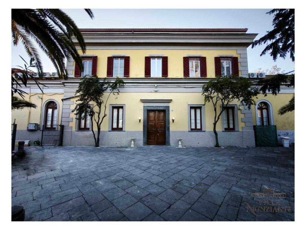 a large yellow building with red windows and a door at Villa Nunziante Grand Estate, Pompei in Scafati