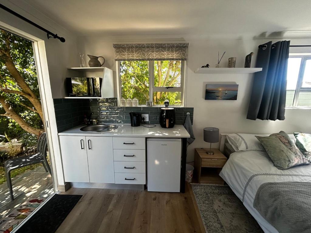 a kitchen with a sink and a bed in a room at Dove Cottage in Oakdale