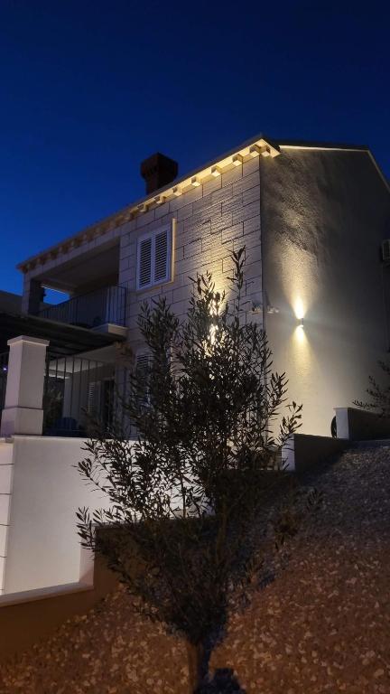 a white house with lights on the side of it at Villa Pero & Jele in Mlini