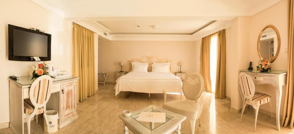 a hotel room with a bed and a table and chairs at Hotel Azimut in Sveti Stefan