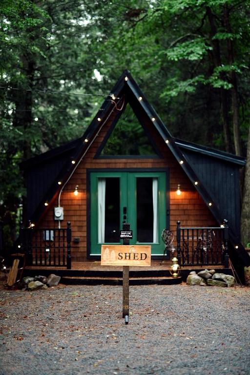 a small cabin with a sign in front of it at Romantic AFrame Cabin with Firepit, BBQ in Pocono Pines