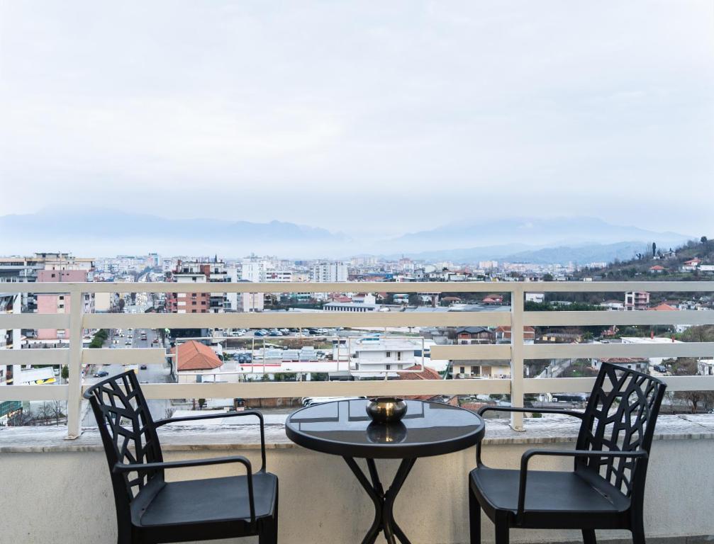 a table and two chairs on a balcony with a view at Luxury City View Apartments with Balcony & Kitchen & Fast Wi-Fi in Shkodër
