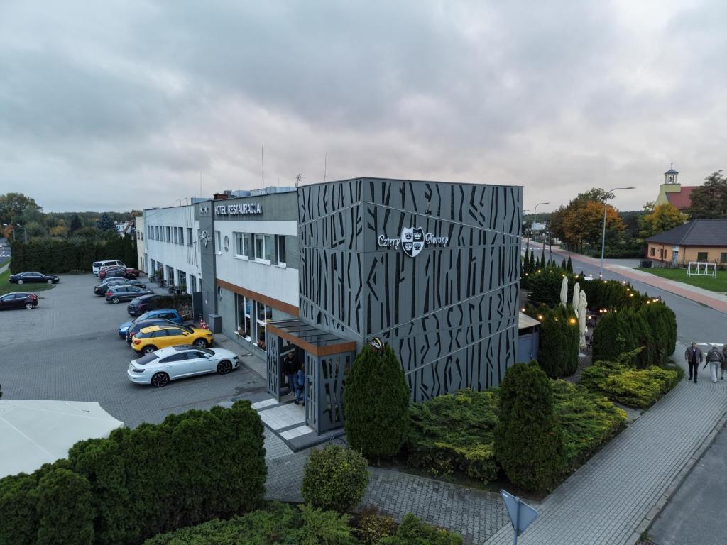 a building with cars parked in a parking lot at Hotel Cztery Korony in Śrem
