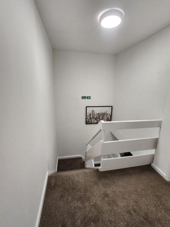 a room with white walls and a stair case at Ensuite premier rooms in Basildon