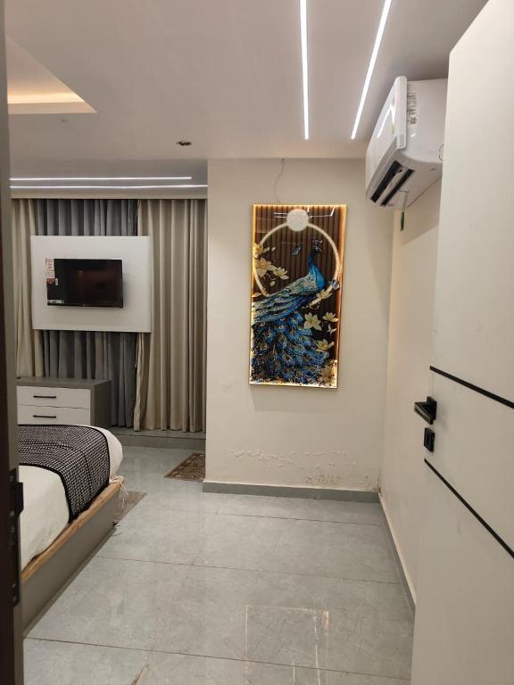 a bedroom with a bed and a painting on the wall at Hotel Red Rose in Vadodara