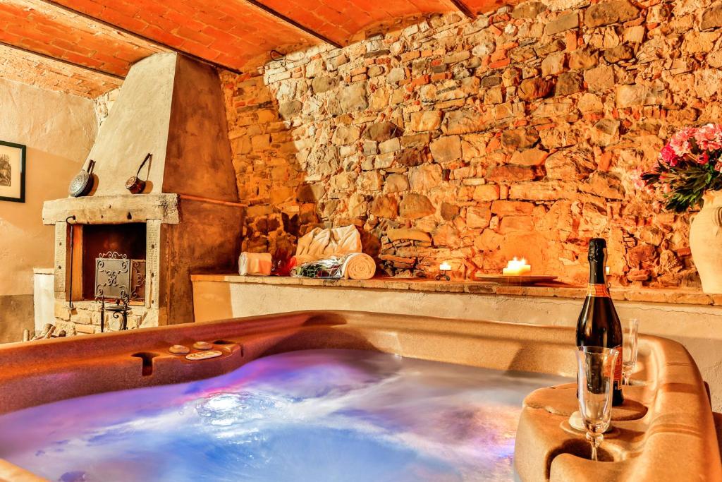a bath tub in a room with a bottle of wine at La Miccia in Pergine Valdarno