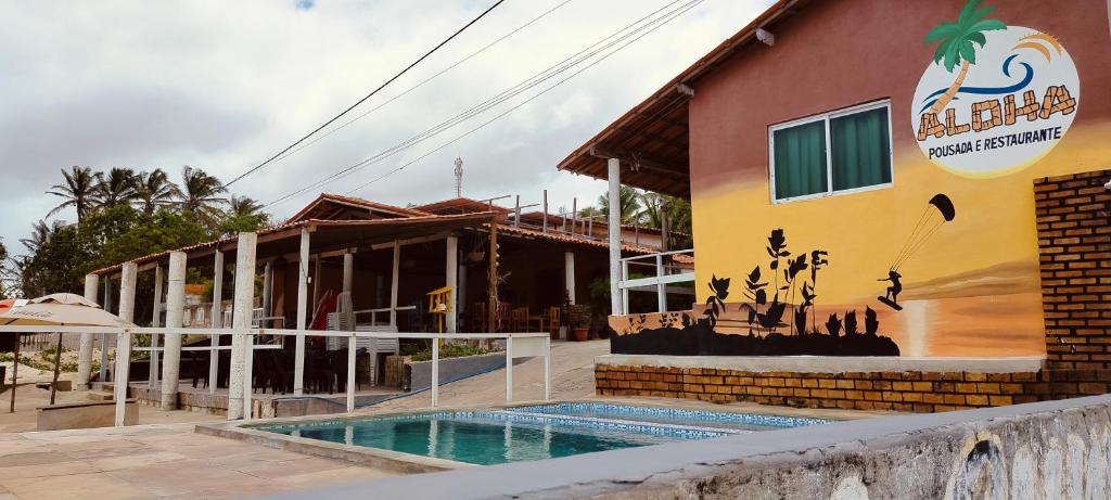 a house with a swimming pool next to a building at Aloha pousada & restaurante in Itapipoca