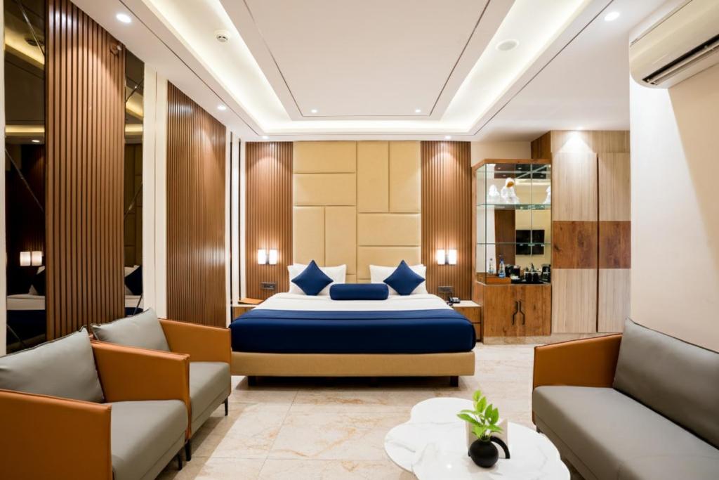 a bedroom with a bed and two couches at Hotel TOS Residency Jubilee hills in Hyderabad