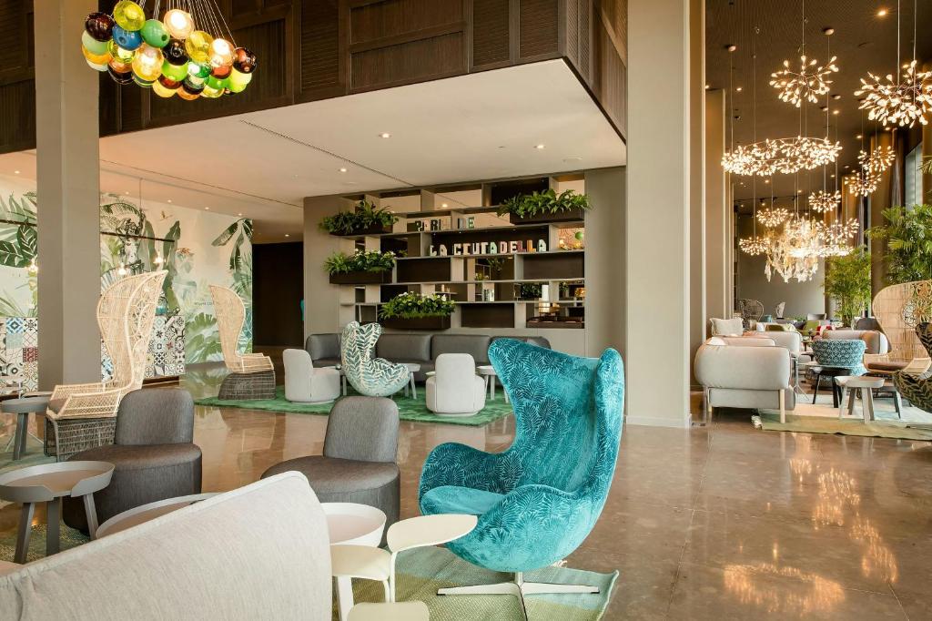 a lobby of a store with chairs and tables at Motel One Barcelona-Ciutadella in Barcelona