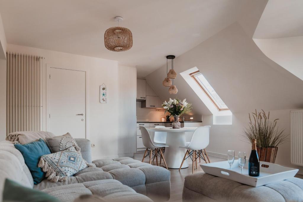 a living room with a couch and a table at Stylish downtown loft and opposite park in Maldegem