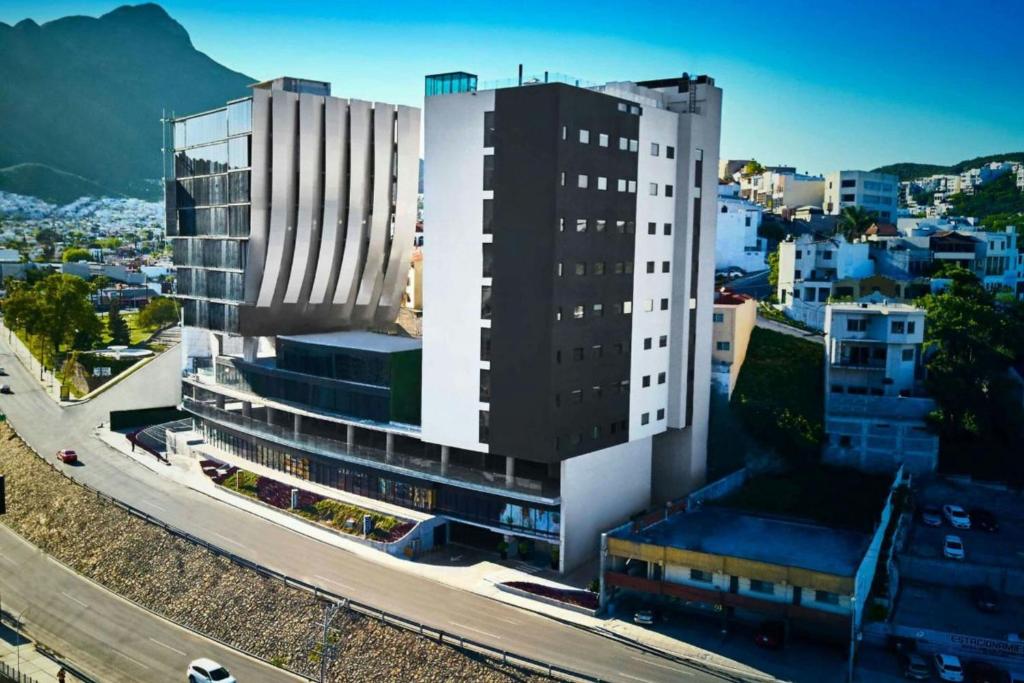 a large white building with a road in front of it at SJ Grand Hotel Monterrey in Monterrey