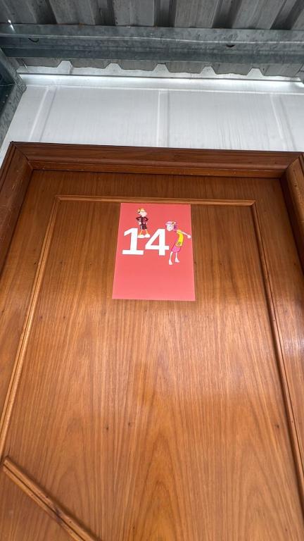 a sign on a wooden door with a number on it at Vila do Chave Dona Florinda 14 in Itajaí