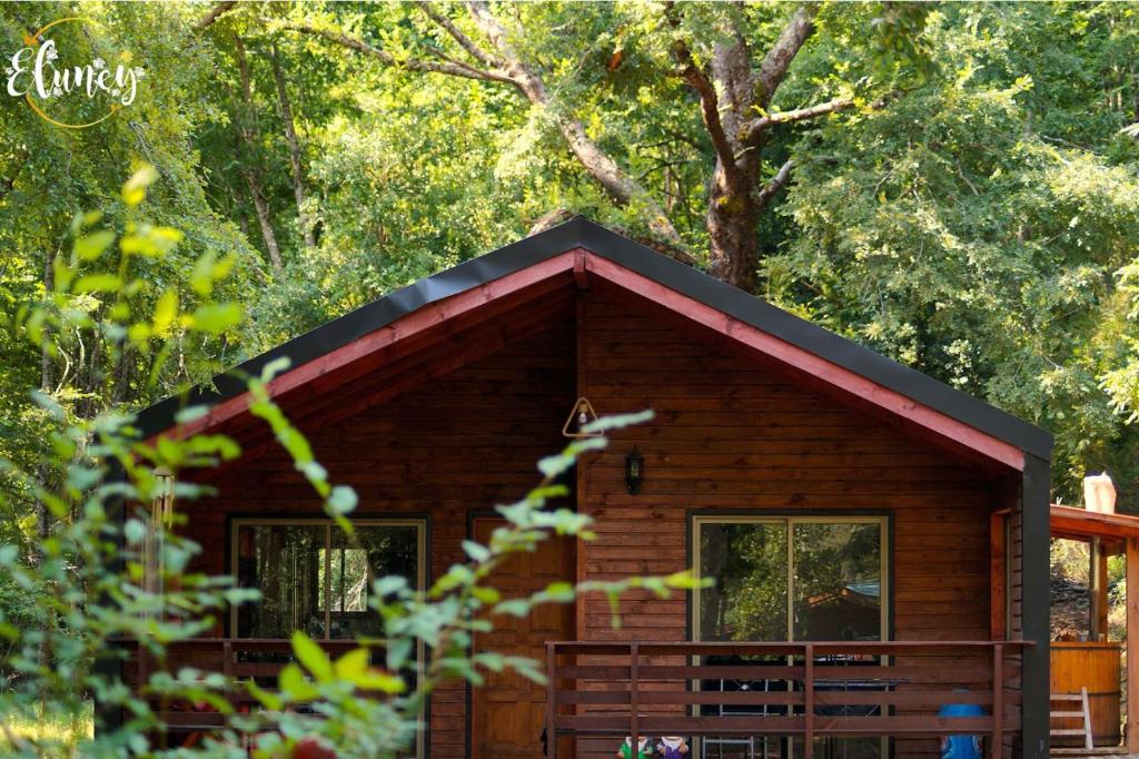 a small log cabin with a red roof at Cafeteria y cabañas Eluney - Koigue in Pucón