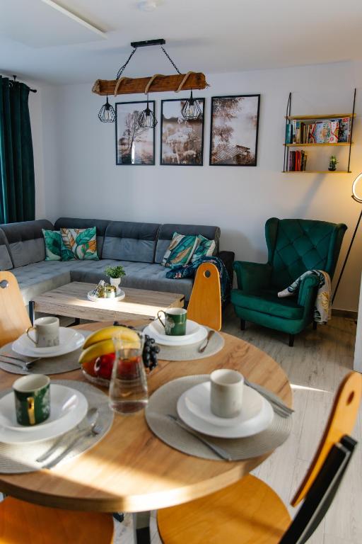a living room with a table and a couch at Apartamenty W Zaciszu in Kamienica Królewska