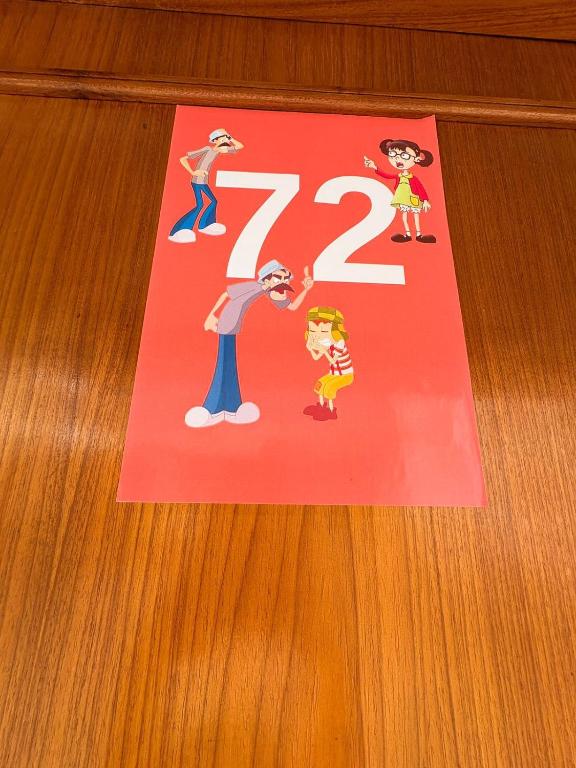 a sign on a table with the number on it at Vila do Chaves Casa Seu Madruga 72 in Itajaí