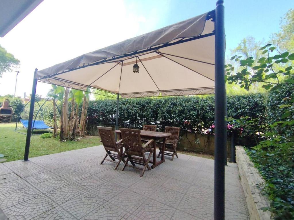 a table and chairs under an umbrella on a patio at HOUSE GARDEN MILANO -Pet Friendly, Giardino Chiuso in Trezzano sul Naviglio
