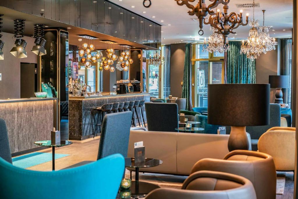 a restaurant with blue chairs and a bar at Motel One Berlin-Ku'Damm in Berlin