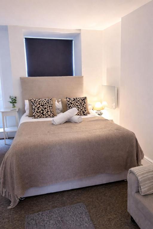 a bedroom with a large bed with a large headboard at Studio 3 - Eign St Hereford in Hereford