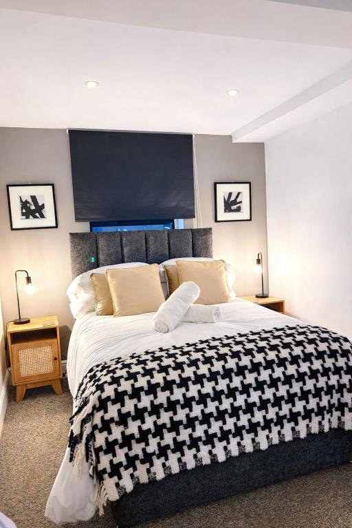 a bedroom with a large bed with a black and white blanket at Studio 5 - Eign St Hereford in Hereford