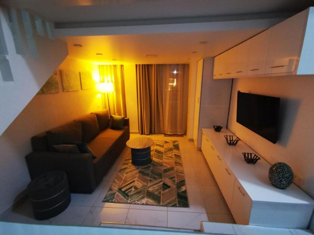 a living room with a couch and a television at Loft VIP in Naama bey in Sharm El Sheikh
