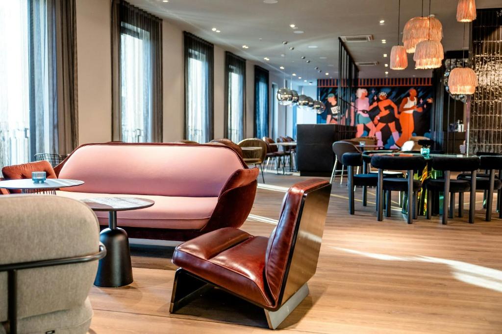 a lobby with chairs and tables and a bar at Motel One Berlin-Potsdamer Platz in Berlin
