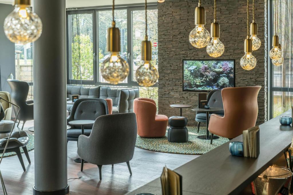 a room with chairs and tables and lights at Motel One Dresden-Palaisplatz in Dresden