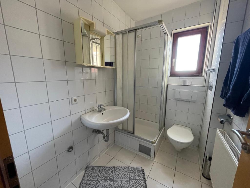 a white bathroom with a sink and a toilet at Monteurwohnung Hohenstadt in Hohenstadt