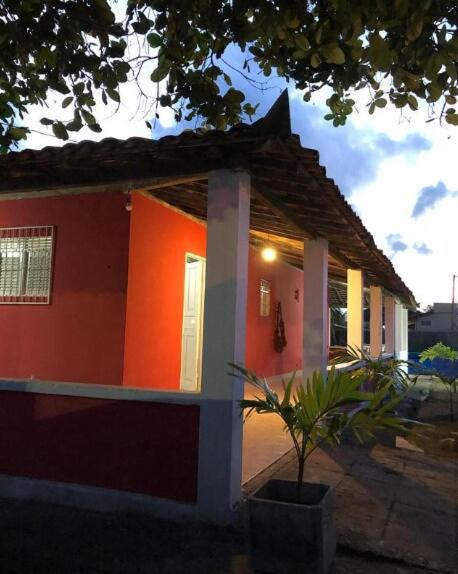 a red house with a potted plant in front of it at Casa Estrela do Mar in Conde