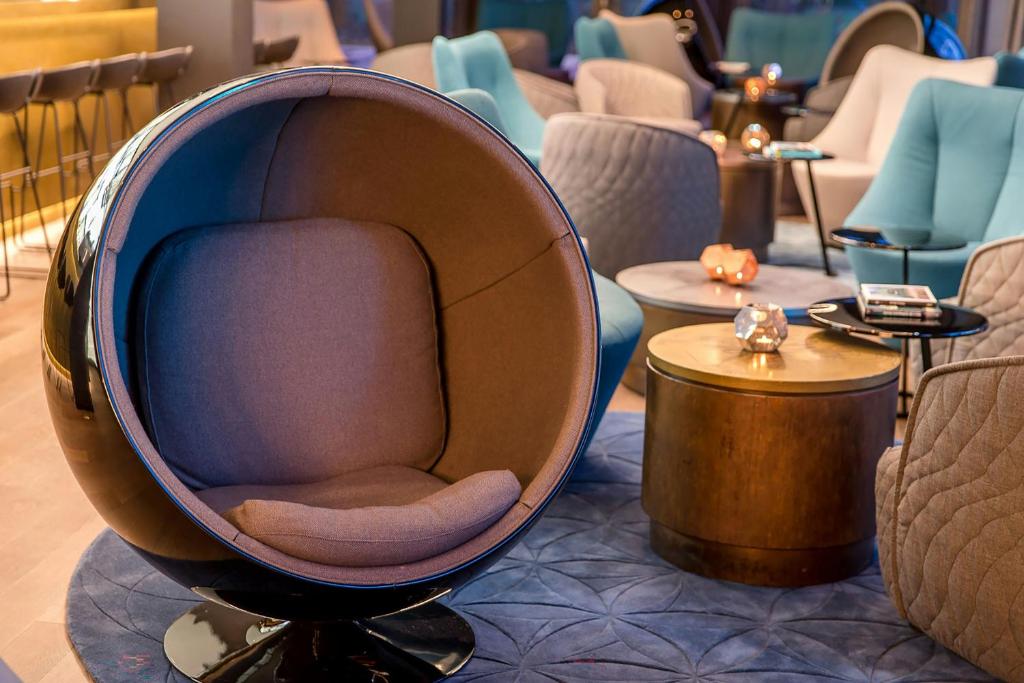 a chair sitting in the middle of a room at Motel One München-Olympia Gate in Munich