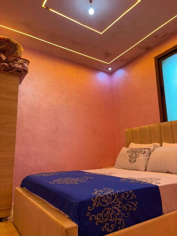 a bedroom with a bed with a blue comforter at Small beautiful villa in Al Massira Airport