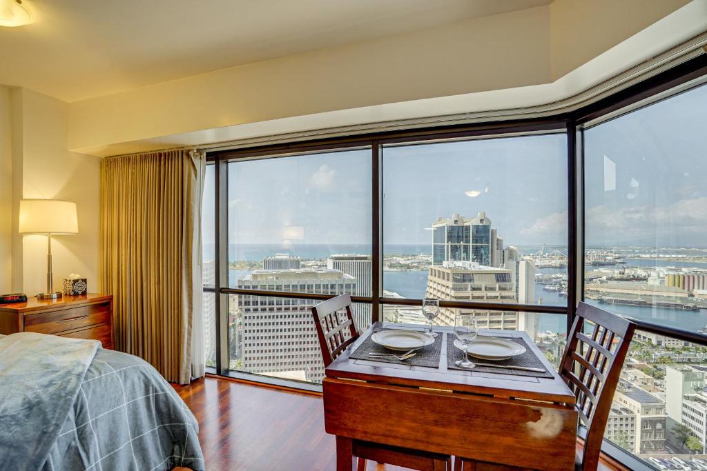 a bedroom with a table and chairs and a large window at Free Parking Pool Harbor View Access Honolulu Gem! in Honolulu