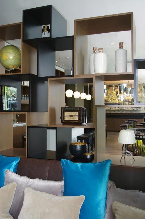 a living room with blue pillows and a couch at Motel One Leipzig-Augustusplatz in Leipzig
