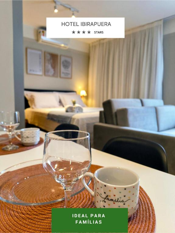 a table with a glass of wine on a table in a hotel room at Flat Hotel Merc Espaçoso Ibirapuera 4 estrelas com Wi-Fi Recepção 24 horas 3PRI in São Paulo