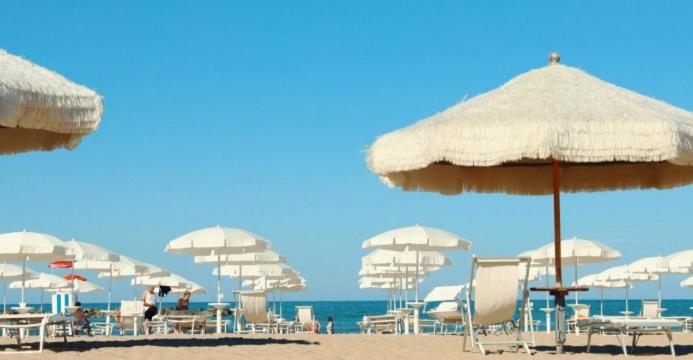a group of chairs and umbrellas on a beach at A 2 passi dal blu in Roseto degli Abruzzi