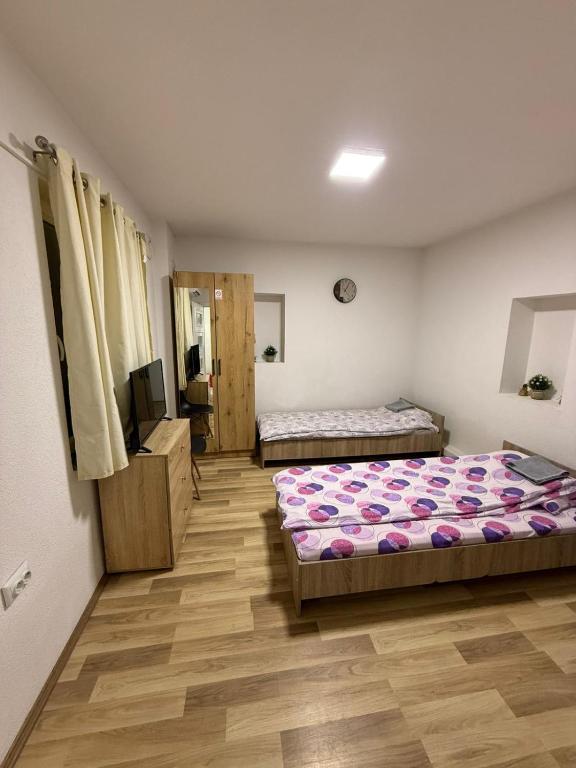 a bedroom with two beds and a flat screen tv at gvero apartment’s in Prilep
