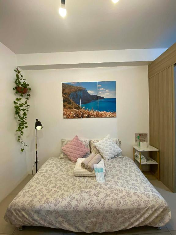 a bedroom with a bed and a painting on the wall at Haven's Suites a place like home in Manila
