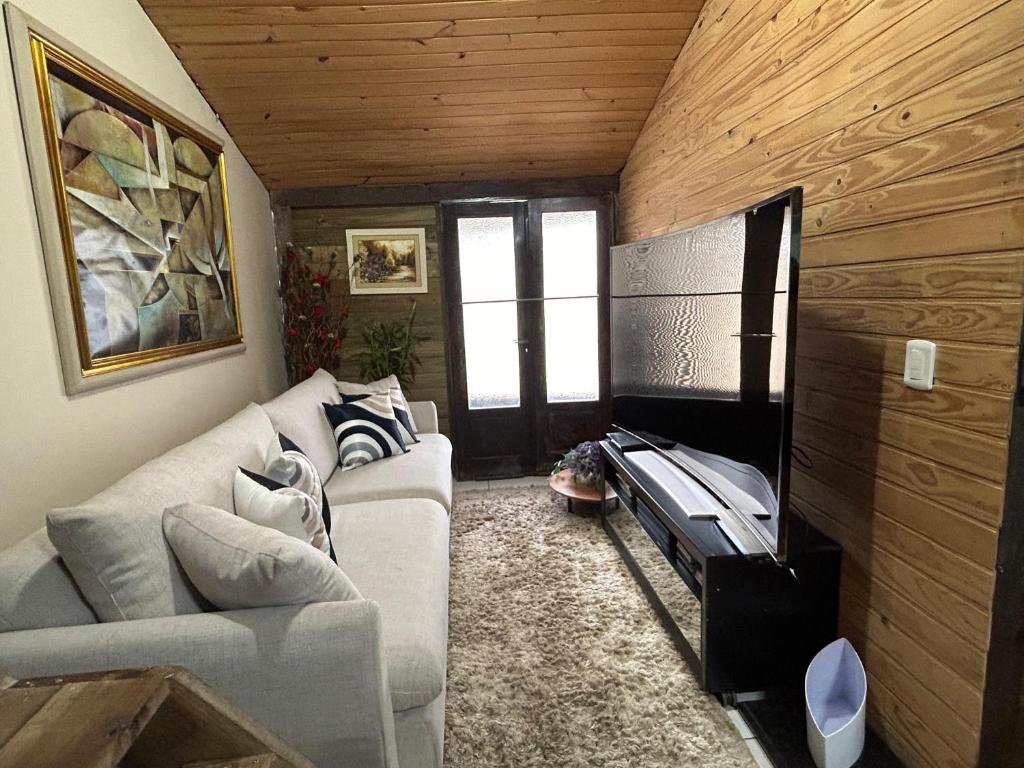 a living room with a couch and a tv at Casa Aconchegante in Pomerode
