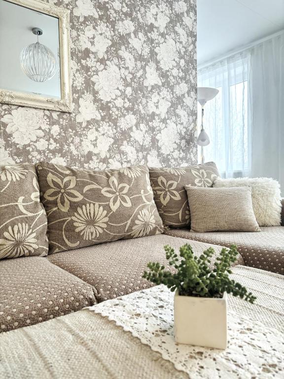 Eine Couch in einem Wohnzimmer mit geblümter Tapete in der Unterkunft Järveküla in Kohtla-Järve
