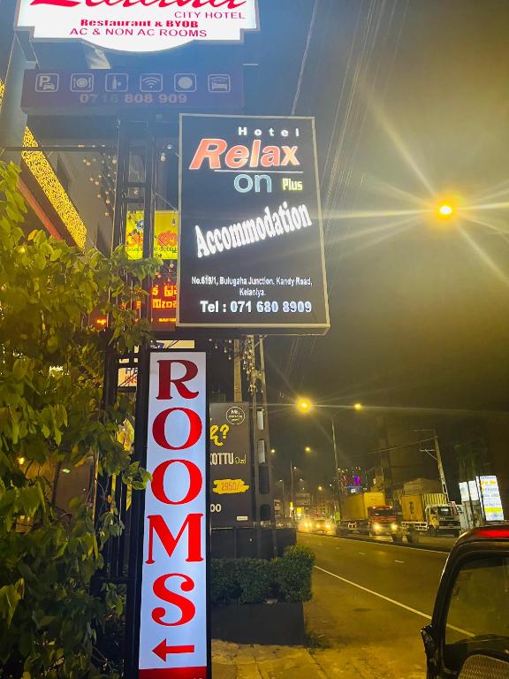 a sign for a restaurant on the side of a street at Relax On Plus Kelaniya in Kelaniya