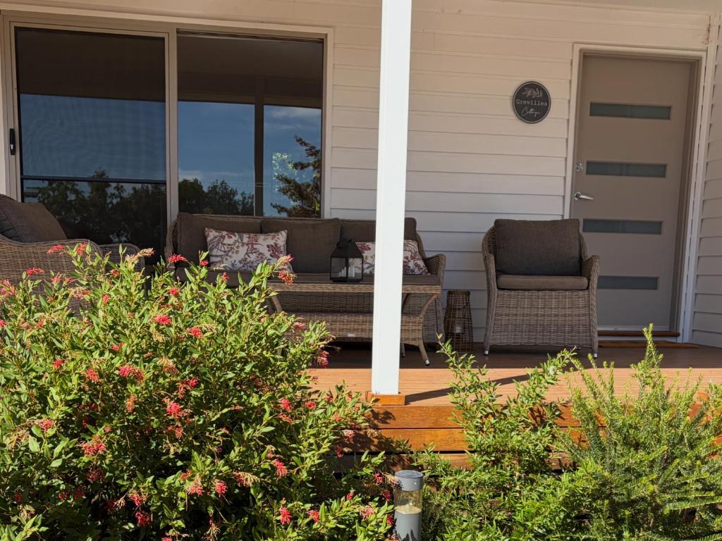 a porch with a couch and chairs on a house at Grevillea Cottage in Murrumbateman