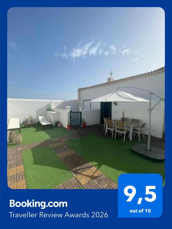 a backyard with a patio with a table and chairs at Casa Brisa Abades in Abades