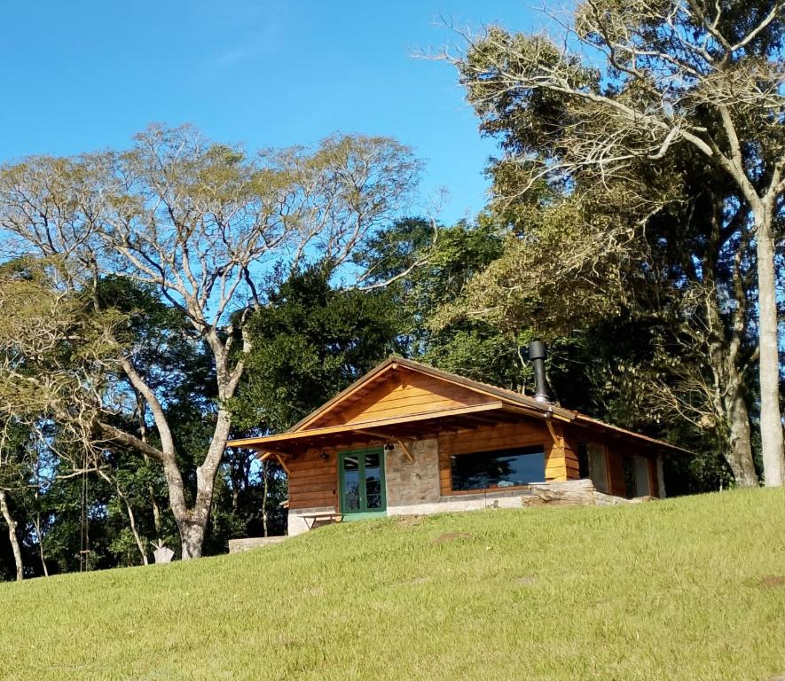 a log cabin on a hill with trees at Morada da Mata in Candelária